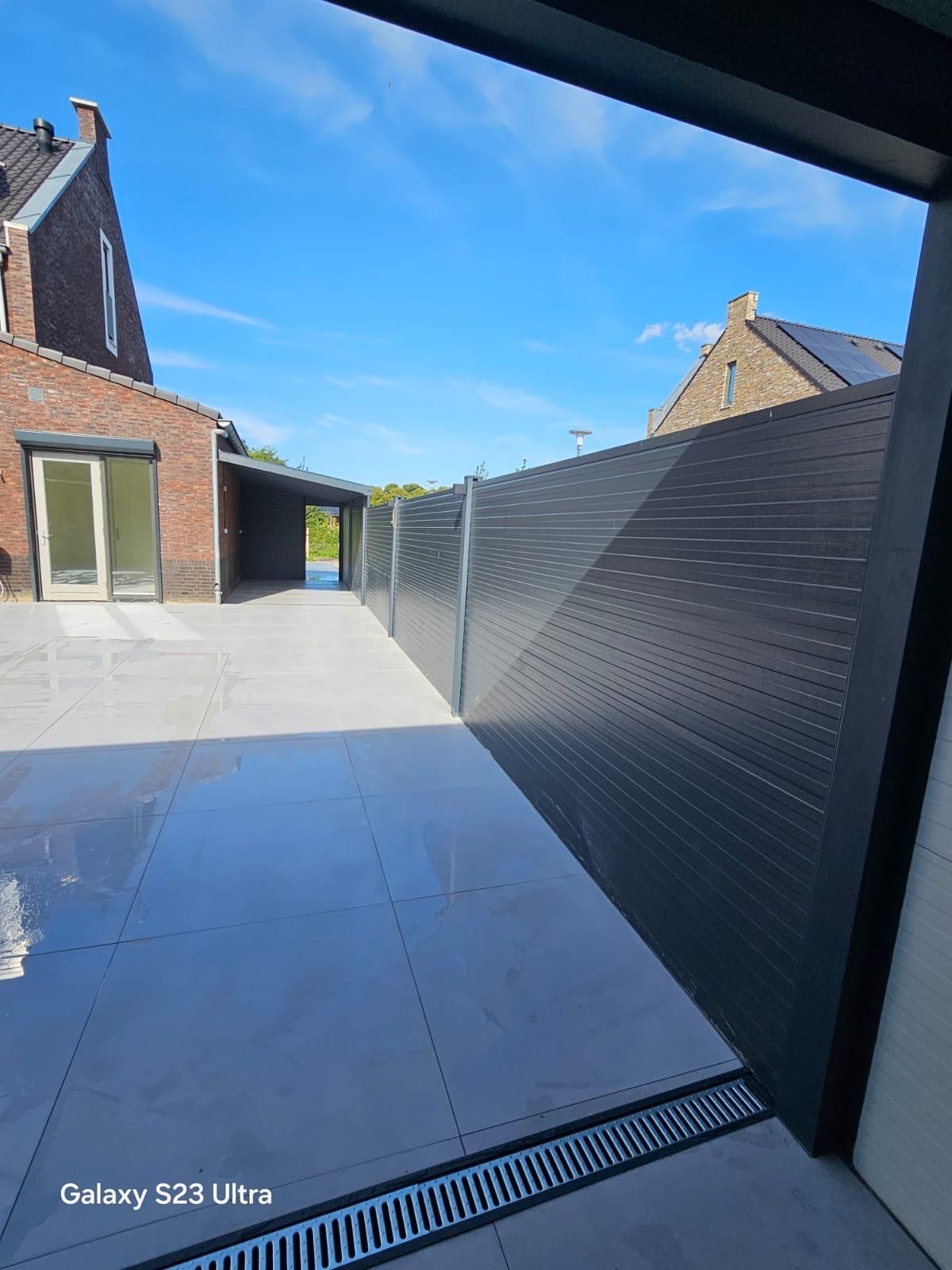 Terrasoverkapping met antraciet frame en tegelvloer