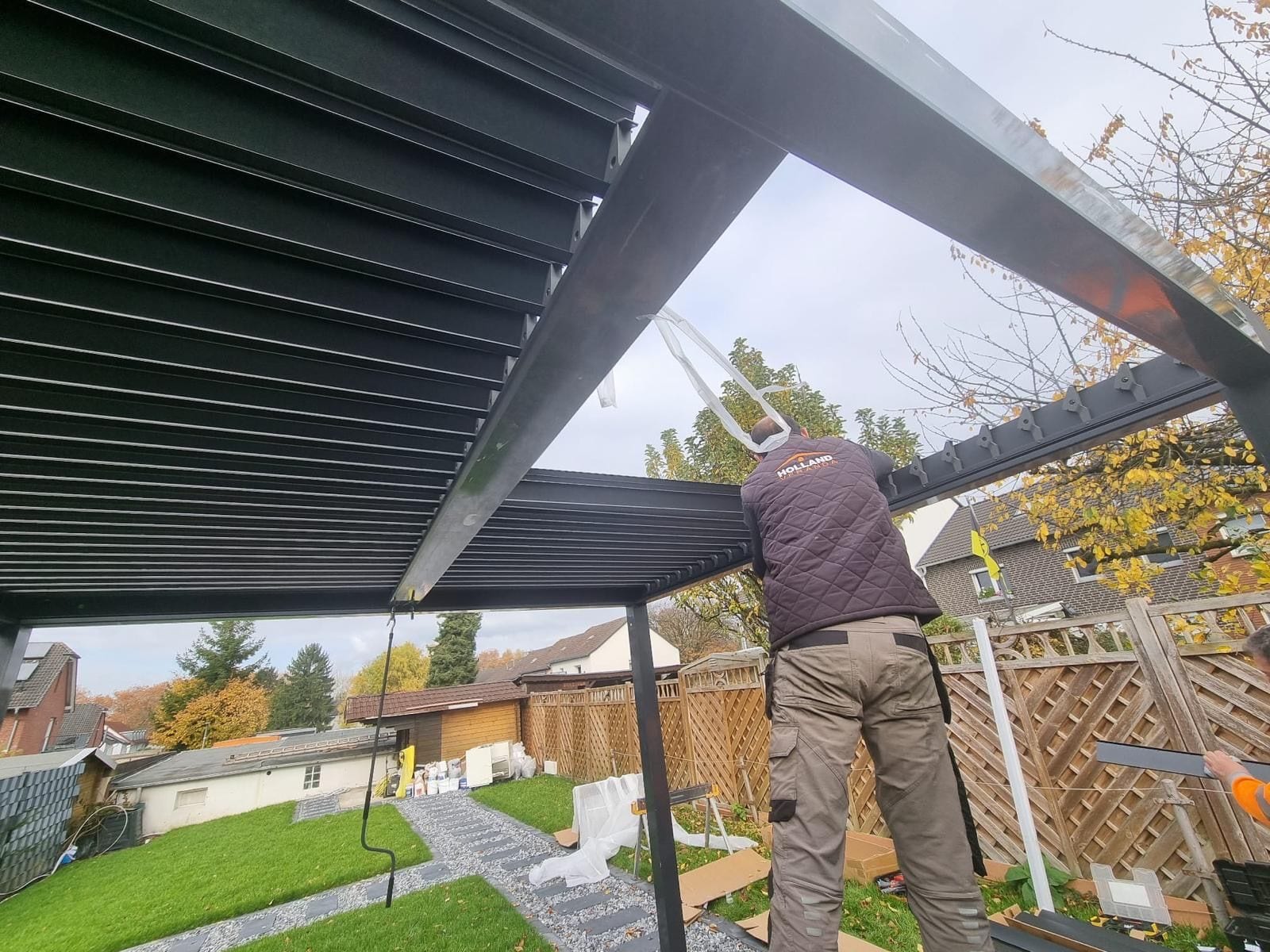 Montage van zonwering onder terrasoverkapping