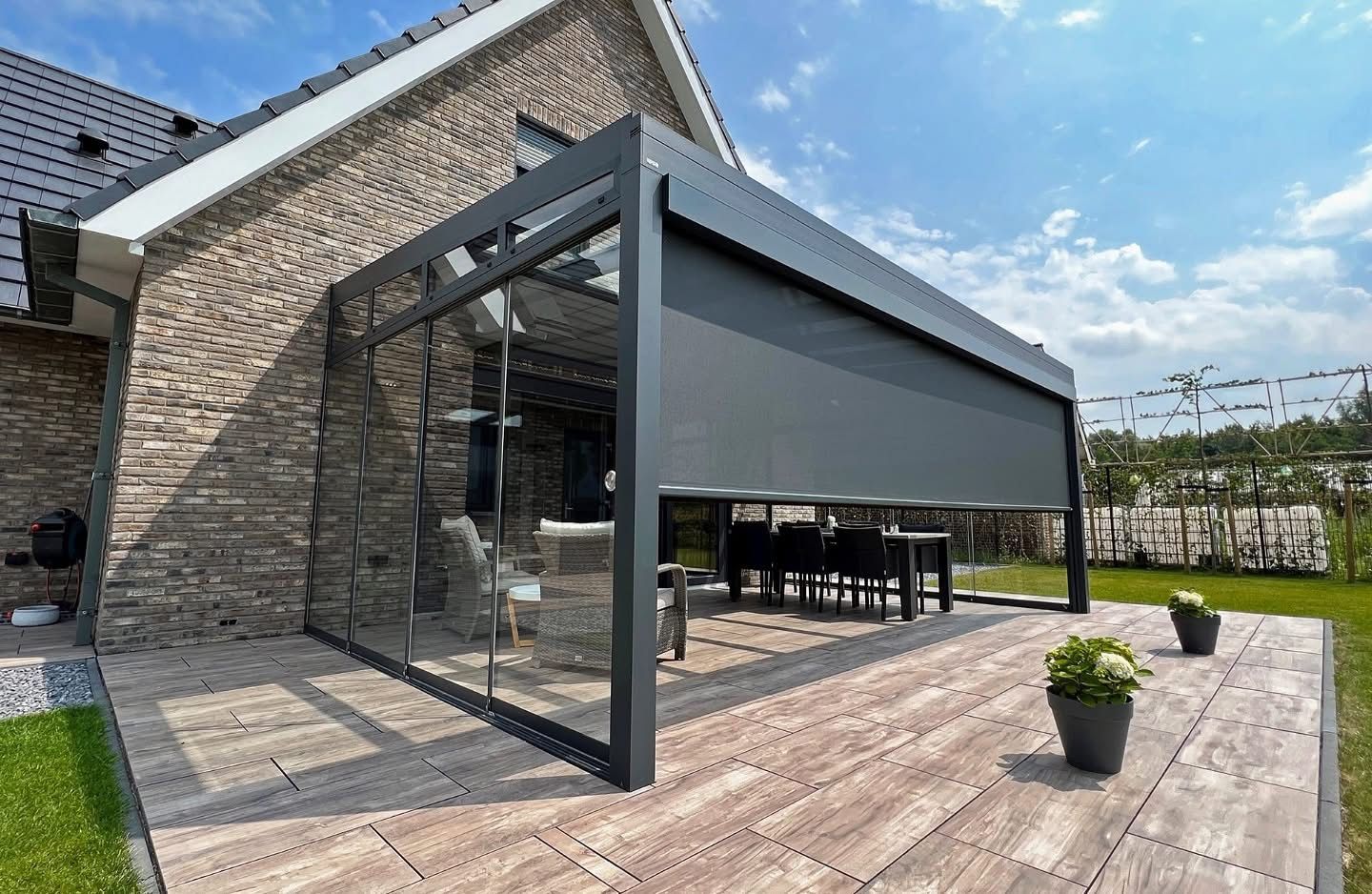 Veranda met zonwering en glazen schuifwanden